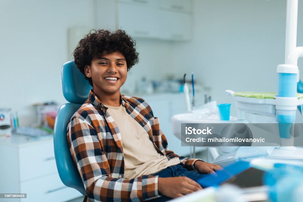 Enjoying his perfect smile Smiling young boy sitting in a dental chair Dentist Stock Photo