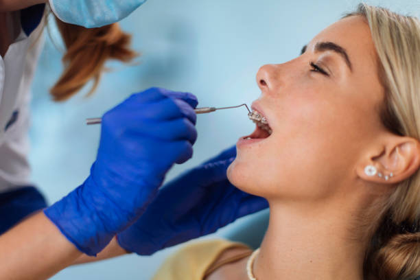 Nothing boosts your confidence like a perfect smile Unrecognizable female dentist adjusting the braces on her young blond patient dental drill stock pictures, royalty-free photos & images