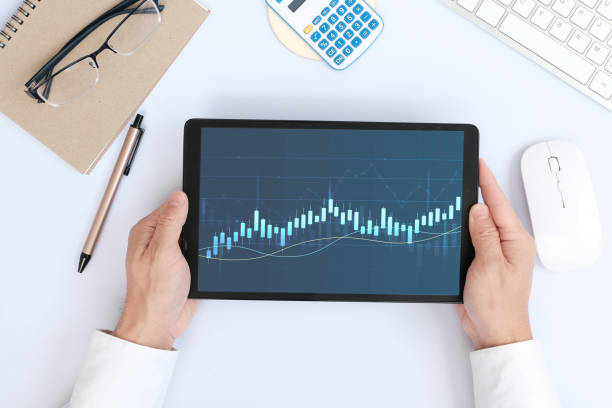 istock Hand uses a tablet to analyze sales data and an economic graph chart in order to restart business growth and analysing forex trading grap 1387381905