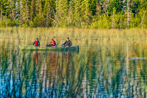 Jasper National Park in the Alberta Rockies  on August 24, 2021:   Family canoeing on Talbot Lake in Jasper National Park, Canada