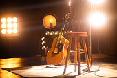 istock Acoustic Guitar on an Empty Stage 1387389124
