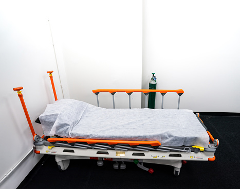 Camp bed with orange bed rails for side effect of Covid-19 vaccinated patient, it is able to be temporarily moved everywhere. This place has an equipment disinfection.