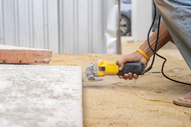 istock Close up worker holds Hand-Hold Sawing Machine and cuts brick foam plate board for wall installation. 1387392421