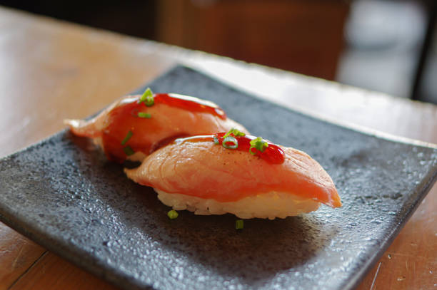 суши из жареного лосося нигири абури с зеленым луком и соевым соусом на черной тарелке - nigiri стоковые фото и изображения