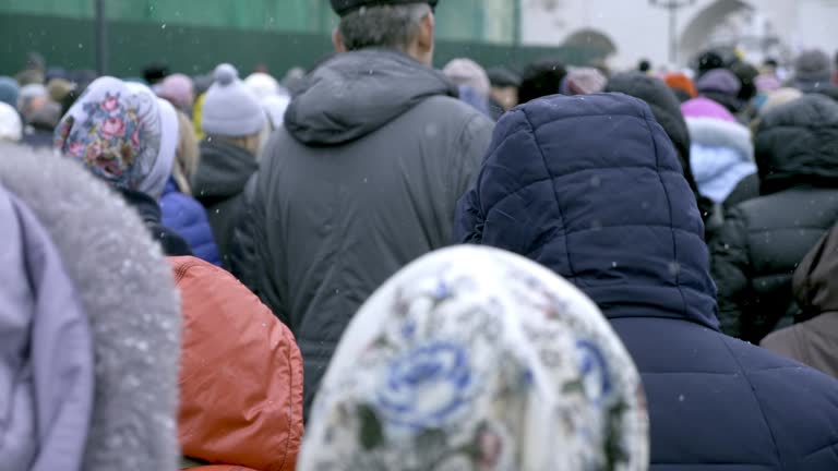 A crowd of migrants is walking along a city street.