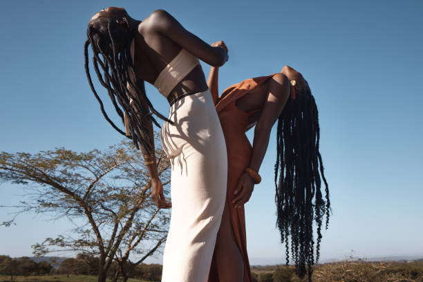 ujęcie dwóch atrakcyjnych młodych kobiet trzymających się za ręce na tle afrykańskiej przyrody - art beauty beautiful hairstyle zdjęcia i obrazy z banku zdjęć