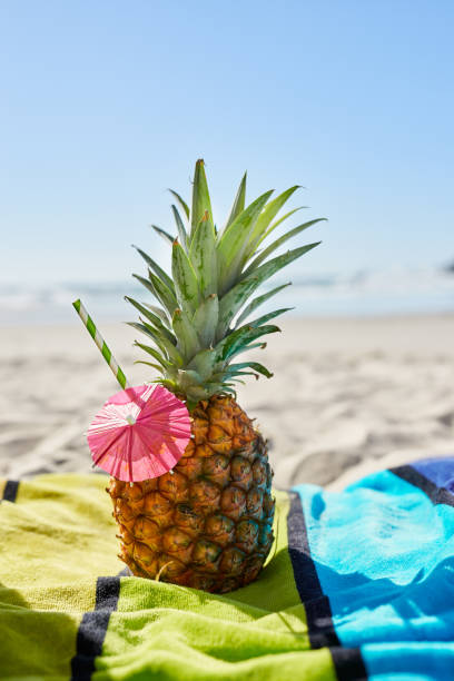 istock Shot of a pineapple cocktail on the beach 1387399876