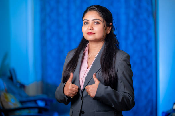 istock Businesswoman Giving Thumbs Up Over Plain Background 1387400609