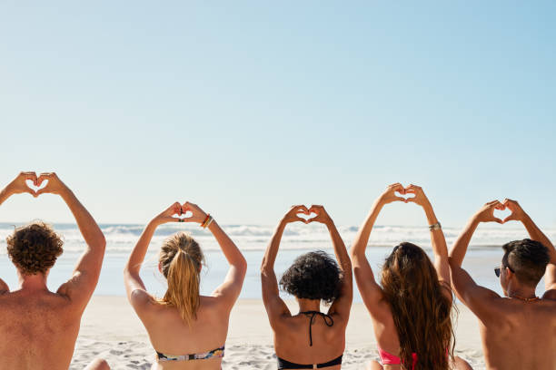 Shot of a group of friends with their hands in the air creating heart shapes Spread love wherever you go heart hands multicultural women stock pictures, royalty-free photos & images