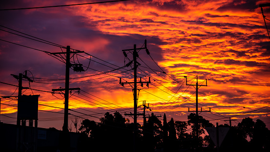 Power lines are in silhouette against a blood red sky for a dramatic urban image