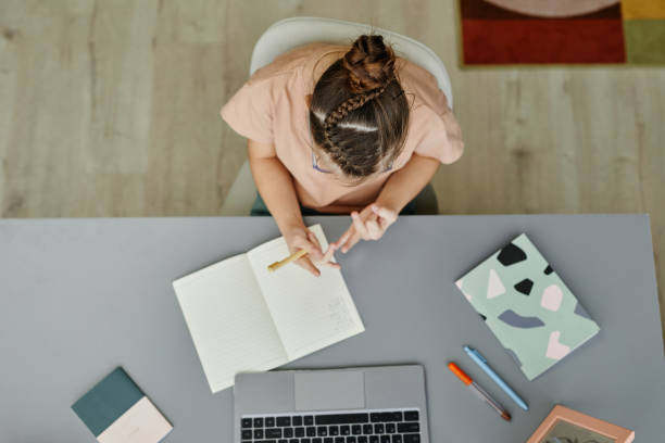 istock Girl with Down Syndrome Studying at Home Top View 1387407091
