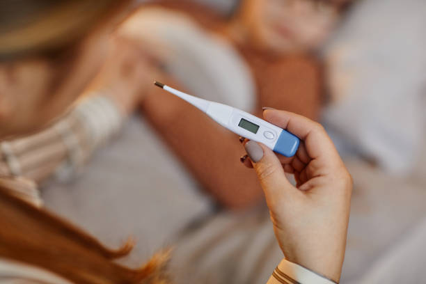 istock Mother Holding Thermometer Close Up 1387407112