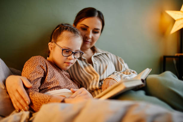 madre e daghter leggono il libro di notte - child reading mother book foto e immagini stock