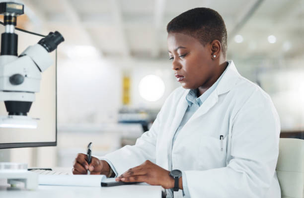 istock Shot of a young scientist writing notes while working in a lab 1387411702