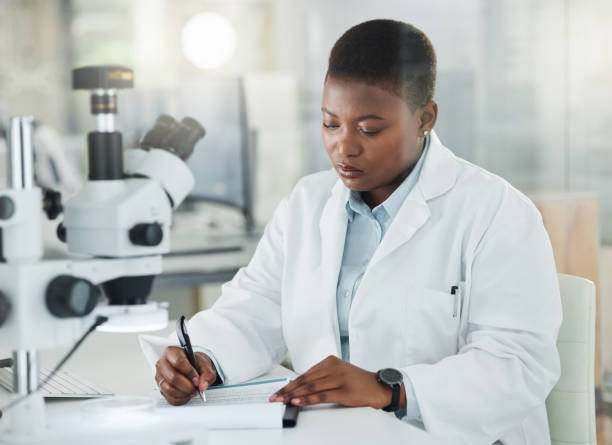 istock Shot of a young scientist writing notes while working in a lab 1387411707
