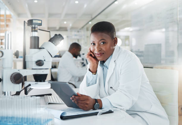 scatto di un giovane scienziato che utilizza un tablet digitale mentre lavora in laboratorio - laboratory scientist african ethnicity science foto e immagini stock