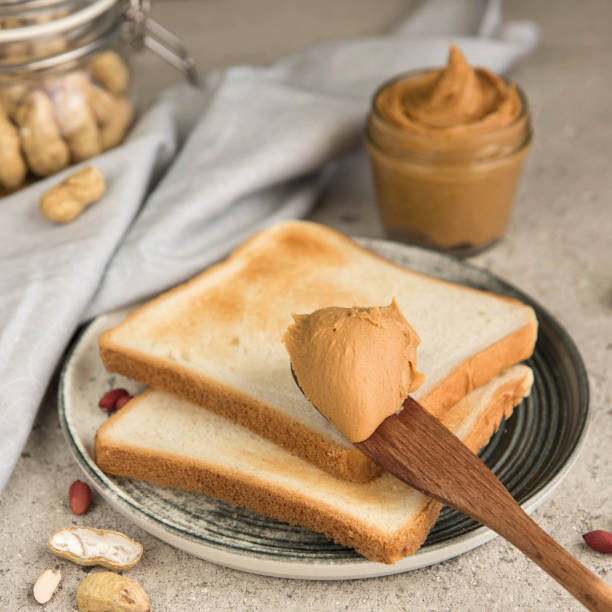 Peanut butter in a Jar, sandwiches with peanut butter and raw peanuts. Peanut sandwich close-up.