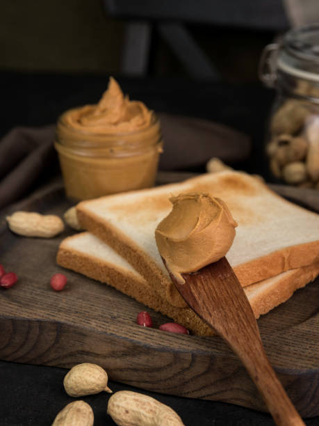 Peanut butter in a Jar, sandwiches with peanut butter and raw peanuts. Peanut sandwich close-up.