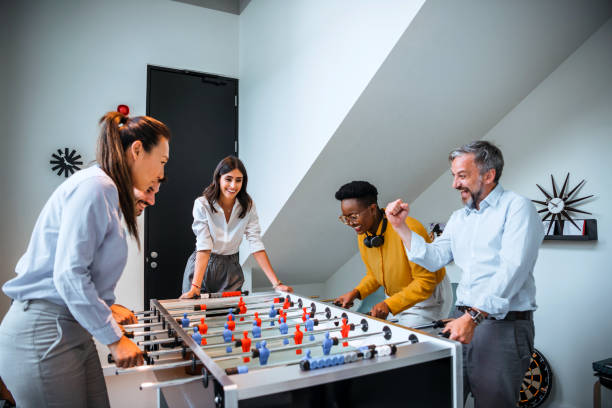 istock Group of Office Workers Enjoying Table Soccer Game Inside the Office During their Break time. 1387418497