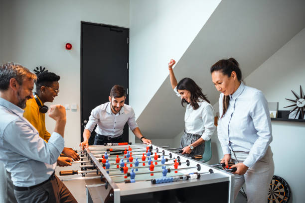 istock Group of Office Workers Enjoying Table Soccer Game Inside the Office During their Break time. 1387418500