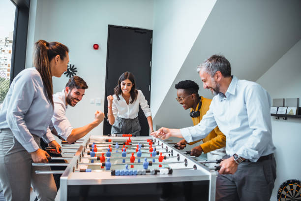 istock Group of Office Workers Enjoying Table Soccer Game Inside the Office During their Break time. 1387418503