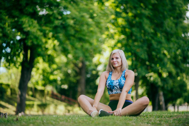 istock female runner stretching in park 1387419435