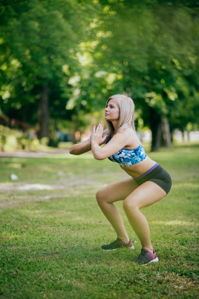 istock female runner stretching in park 1387419437
