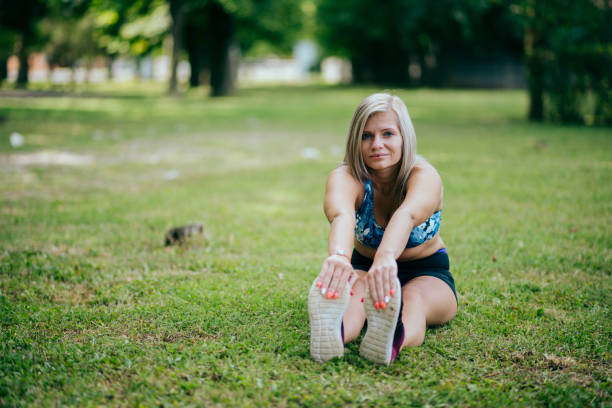 istock female runner stretching in park 1387419438