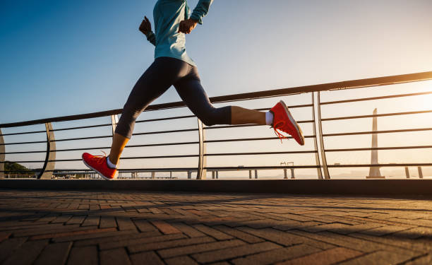 fitness mujer corredora corriendo en puente junto al mar - jumping women running vitality fotografías e imágenes de stock