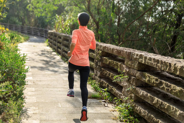 istock Asian woman jogging in park 1387421587