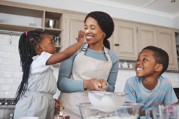 photo d’une mère en train de cuisiner avec ses enfants à la maison - cookie mother 30s parent photos et images de collection