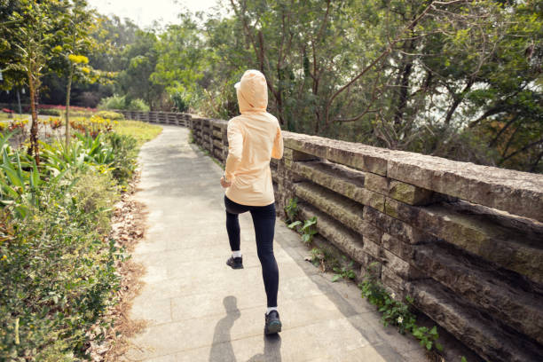 istock Asian woman jogging in park 1387421953
