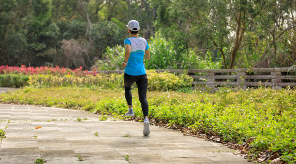 istock Asian woman jogging in park 1387423232