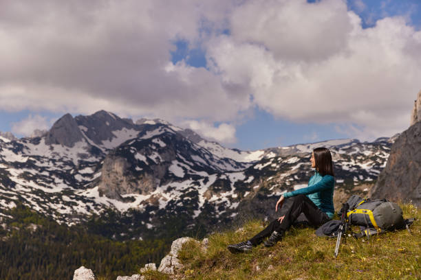 istock Female hiker with backpack relaxing and enjoying the view 1387423589