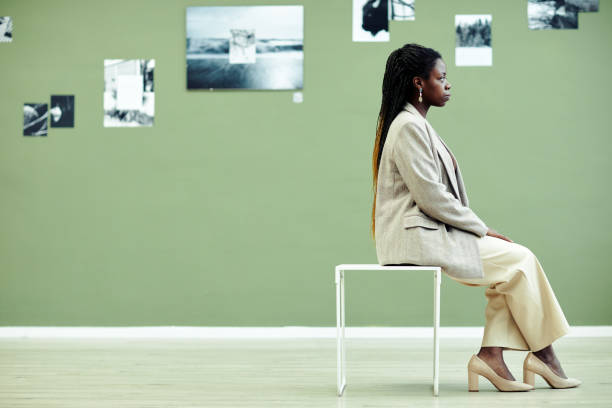 istock Black Woman Sitting In Art Gallery 1387425607