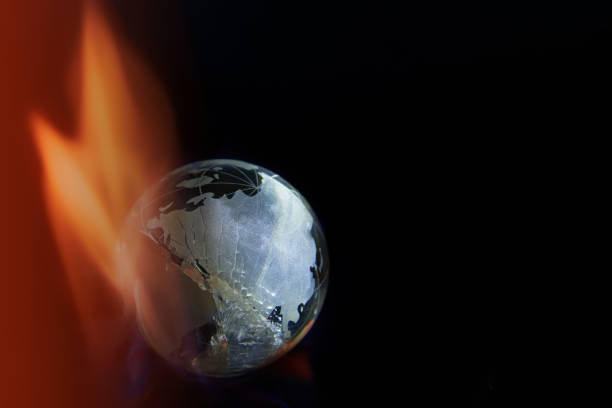 istock Broken glass planet earth on fire on black background, copy space. 1387425962