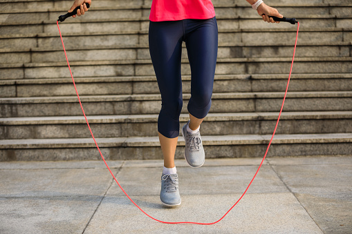 Fitness woman jumping rope in city