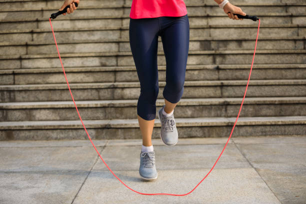 Fitness woman jumping rope in city stock photo