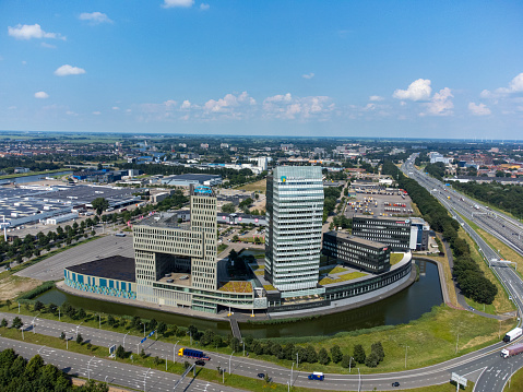 Amsterdam, The Netherlands-April 2022; High angle view of highway and train tracks and public transit exchange on Zuidas financial district and RAI Amsterdam Convention Centre and Amstel Tower visible