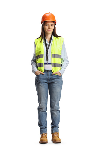 Full length portrait of a young female site engineer with a safety vest and hardhat isolated on white background