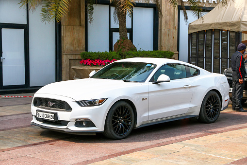 New Delhi, India - February 25, 2022: White luxury car Ford Mustang in a city street.