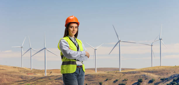 istock Young female engineer with a safety equipment on a wind farm 1387428516