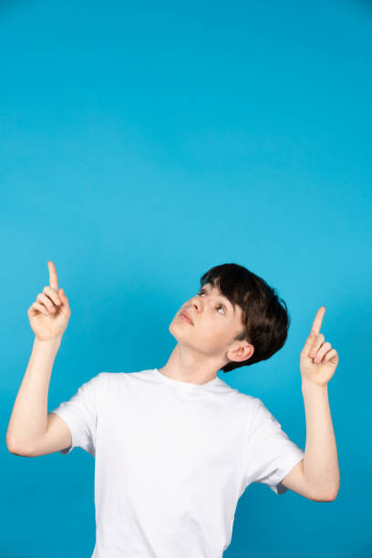 istock Teenager boy pointing up 1387429780