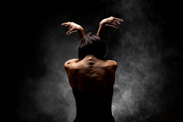 istock half silhouette modern ballet dancer posing on dark background with smoke 1387430047