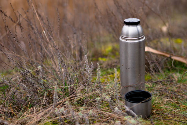 istock thermos with tea on the grass 1387430474