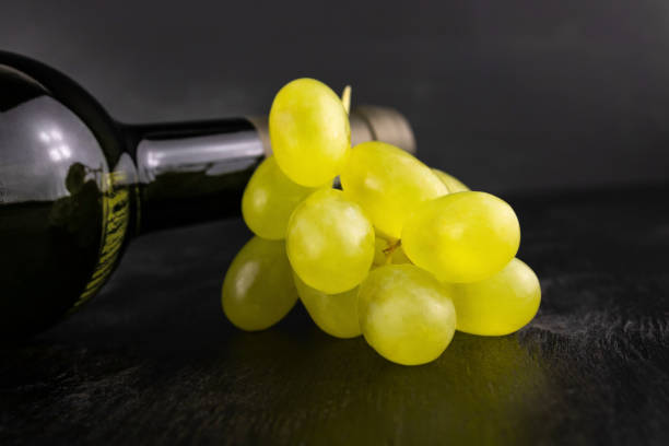 istock Bottle of wine and white grapes 1387431266