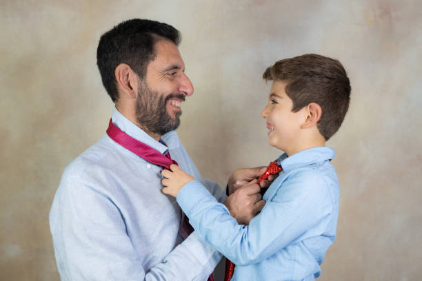 Happy Father's Day text in black with a striped purple and sliver tie on a pink background.