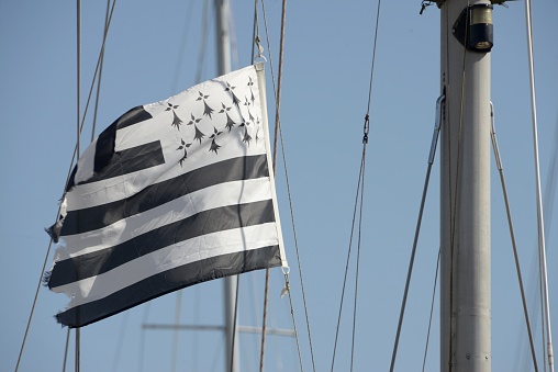 Damaged flag of Brittany hanging from a boat mast