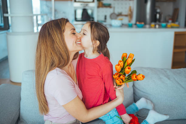 istock Daughter Giving Flowers To Mom. 1387432093
