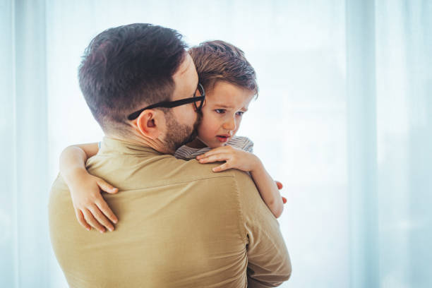 istock Portrait of a crying child on hands a father. 1387434628